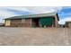 Single-story home with metal roof and stone accents, surrounded by desert landscape with shed at 1880 Ash St, Overton, NV 89040