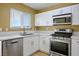 Bright kitchen with stainless steel appliances, white cabinets, and sleek countertops at 2032 Kingswinford Dr, North Las Vegas, NV 89032