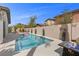 The backyard pool area features a fire pit, lounge chairs and lush landscaping at 2098 Valley Sand St, Las Vegas, NV 89135