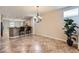 Bright dining area features a modern chandelier, tiled floors, and a view of the kitchen and breakfast bar at 2148 Shadow Canyon Dr, Henderson, NV 89044