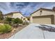 Lovely desert home with a tiled roof, palm trees, a long driveway and attached two-car garage at 2148 Shadow Canyon Dr, Henderson, NV 89044
