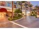 Beautiful entrance and exterior view of the condos with lush landscaping, brick walkway, and storefronts at 2240 Village Walk Dr # 2207, Henderson, NV 89052