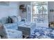 Comfortable living room with a blue sofa, patterned rug, shelving and a view of palm trees from the balcony at 2240 Village Walk Dr # 2207, Henderson, NV 89052