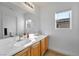Bright bathroom featuring double sinks, wooden cabinets, and a large mirror at 2293 Bull Lake Dr, Henderson, NV 89052