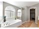 Inviting bathroom featuring a soaking tub, glass shower, and neutral tiling at 2293 Bull Lake Dr, Henderson, NV 89052