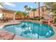 Backyard pool featuring a rock waterfall, lounge chairs, and surrounding palm trees at 2293 Bull Lake Dr, Henderson, NV 89052