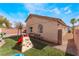 View of backyard with artificial grass, play area, benches, and patio at 2410 Morocco Ave, North Las Vegas, NV 89031