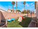 Fun backyard with palm trees, artificial grass, play area, and basketball hoop at 2410 Morocco Ave, North Las Vegas, NV 89031