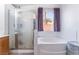 Bright bathroom features a glass shower and separate tub at 2410 Morocco Ave, North Las Vegas, NV 89031