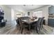Bright dining room with grey wood floors, a wooden table, and seating for six at 2410 Morocco Ave, North Las Vegas, NV 89031