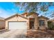 Charming single-story home featuring a well-maintained lawn, a two-car garage, and a welcoming entrance at 2410 Morocco Ave, North Las Vegas, NV 89031