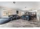 Open-concept living space with two sofas, grey wood floors, and bright kitchen in the background at 2410 Morocco Ave, North Las Vegas, NV 89031