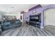 Bright, open-concept space with sofa, grey wood floors, and television at 2410 Morocco Ave, North Las Vegas, NV 89031