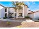 A two-story condo building featuring earth-toned stucco, iron railings, mature trees, and low-maintenance landscaping at 2615 W Gary Ave # 1089, Las Vegas, NV 89123