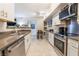A modern kitchen boasts stainless steel appliances, neutral countertops and white cabinetry with access to a dining area at 2615 W Gary Ave # 1089, Las Vegas, NV 89123