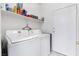 Functional laundry room featuring a white washer and dryer set with overhead shelving at 2615 W Gary Ave # 1089, Las Vegas, NV 89123