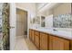 Bright bathroom featuring a dual sink vanity with a large mirror and a walk-in closet at 2883 Mount Hope Dr, Las Vegas, NV 89156
