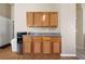 This kitchen features wooden cabinets, granite countertop, and a convenient beverage station at 2883 Mount Hope Dr, Las Vegas, NV 89156