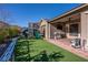 Backyard features artificial turf, patio with grill, playground, well-maintained landscaping, and covered patio at 2931 Raywood Ash Dr, Las Vegas, NV 89138