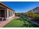 Well-maintained backyard features artificial turf, a seating area, and mature landscaping for outdoor living and enjoyment at 2931 Raywood Ash Dr, Las Vegas, NV 89138