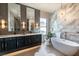 Spa-like bathroom with a soaking tub, marble accents, dual vanities, and statement lighting at 312 Proud Eagle Ln, Las Vegas, NV 89144