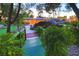 Expansive backyard featuring a lush lawn, a large boulder water feature, and mature trees at 3132 El Camino Rd, Las Vegas, NV 89146
