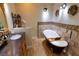 Bathroom featuring a black soaking tub, wood-style tile, and a vintage vanity at 3132 El Camino Rd, Las Vegas, NV 89146