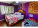 Purple bedroom with a sunny window, hardwood floors, and colorful tapestries at 3132 El Camino Rd, Las Vegas, NV 89146