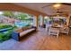 Expansive covered patio with comfortable seating, dining area, and views of the pool and lush backyard at 3132 El Camino Rd, Las Vegas, NV 89146