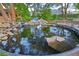 Scenic backyard pond with rock accents, mature trees, and colorful koi fish for a tranquil retreat at 3132 El Camino Rd, Las Vegas, NV 89146