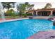Beautiful backyard pool with rock features, waterfall, and covered patio offers a luxurious outdoor experience at 3132 El Camino Rd, Las Vegas, NV 89146