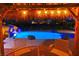 Night view of the stunning rock pool with slide and waterfall from the cozy table and chairs on the patio at 3132 El Camino Rd, Las Vegas, NV 89146