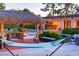 Backyard oasis featuring a tiki hut with dining and lounge seating, overlooking a pool and lush landscaping at 3132 El Camino Rd, Las Vegas, NV 89146
