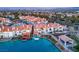 Aerial view of waterfront townhomes with red tile roofs, private docks, and lush landscaping in a well-planned community at 3173 Lido Isle Ct, Las Vegas, NV 89117
