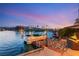 Dock with a boat, outdoor seating, and lighting for evening enjoyment on the water at 3173 Lido Isle Ct, Las Vegas, NV 89117