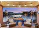 Covered patio with seating and waterfront views and boat dock at 3173 Lido Isle Ct, Las Vegas, NV 89117