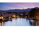 Scenic waterfront view of townhouses, boats, and the mountains during sunset with beautiful reflections in the water at 3173 Lido Isle Ct, Las Vegas, NV 89117