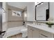 Bathroom with tiled bathtub, vanity with modern sink, and decorative mirror at 3228 Robin Cir, Las Vegas, NV 89121