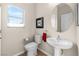 Cozy half bathroom with pedestal sink and window offering natural light at 3405 Robust Robin Pl # 3, North Las Vegas, NV 89084