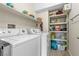 Efficient laundry room equipped with a washer, dryer, and shelving for storage at 3405 Robust Robin Pl # 3, North Las Vegas, NV 89084