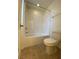 Bathroom with white tiled shower/tub and a standard toilet on a tiled floor at 346 Andy Wheeler Dr, Henderson, NV 89011