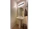 Powder room with pedestal sink, decorative mirror, and tile flooring at 346 Andy Wheeler Dr, Henderson, NV 89011