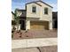 Two-story home featuring a two-car garage, desert landscaping, and a classic stucco facade at 346 Andy Wheeler Dr, Henderson, NV 89011