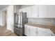 A modern kitchen featuring stainless steel appliances, white cabinets, and granite countertops at 4040 Beech Fern Ave, North Las Vegas, NV 89084