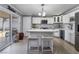 Bright kitchen features a center island with seating, white cabinets and a stainless refrigerator at 4363 Del Santos Dr, Las Vegas, NV 89121