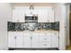 Charming kitchen with white cabinetry, stainless steel microwave, and unique backsplash design at 4363 Del Santos Dr, Las Vegas, NV 89121