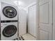 Laundry room with a stacked washer and dryer, shelving, and access to additional storage at 4363 Del Santos Dr, Las Vegas, NV 89121