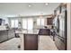 Modern kitchen with stainless steel appliances, granite island and barstool seating, and open to living room at 4423 Creekside Cavern Ave, North Las Vegas, NV 89084