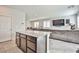 Open kitchen island with granite countertops, bar stool seating and view to the living room area at 4423 Creekside Cavern Ave, North Las Vegas, NV 89084