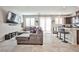 Comfortable living room features a large sectional sofa, tile floors, and an open floor plan at 4423 Creekside Cavern Ave, North Las Vegas, NV 89084